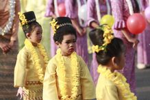 Crianças em trajes tradicionais participam num evento cultural