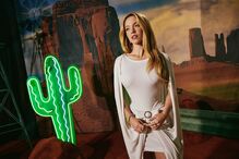 Sydney Sweeney num cenário com cato de néon