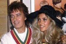 O músico Bill Wyman posa com uma mulher não identificada