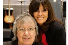 Bill Wyman, baixista dos Rolling Stones, surge sorridente com uma senhora