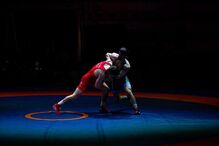 Dois lutadores competem num ringue azul e laranja