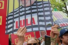 Manifestação com cartazes de Lula da Silva, com algemas