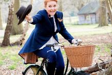 Sarah Ferguson surge sorridente numa bicicleta