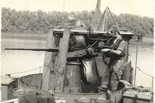 Militar opera armamento pesado num barco
