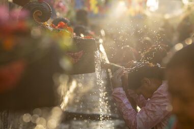  Devotos hindus banham-se sob 22 jatos de água durante a festa da deusa Rama Navmi