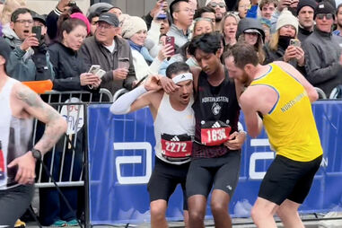 Atleta cai exausto perto da meta na Maratona de Boston e colegas param para o ajudar 