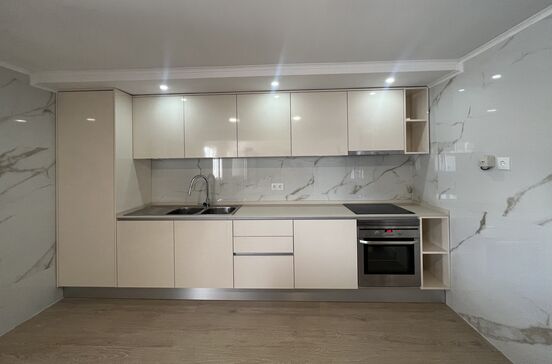 Cozinha moderna com armários, lava-loiça e forno integrados