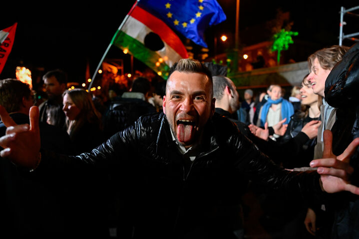 Homem celebra a derrota de Viktor Orbán