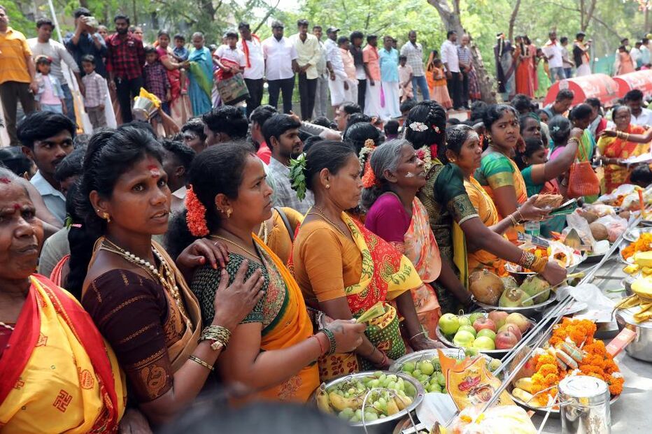 Devotos hindus fazem oferendas enquanto participam numa procissão religiosa