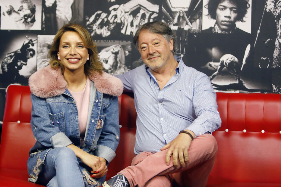 Retrato de Luciana Abreu e um homem sorrindo num sofá vermelho