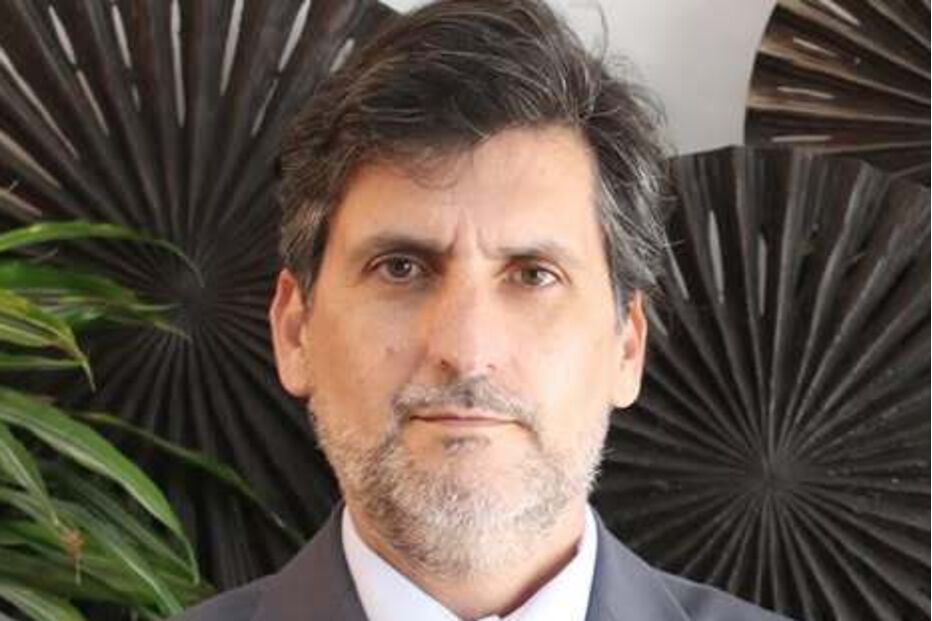 Homem de fato e gravata posa para a câmara num ambiente profissional