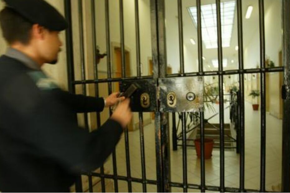 Guarda prisional fecha cela, mantendo segurança na instituição