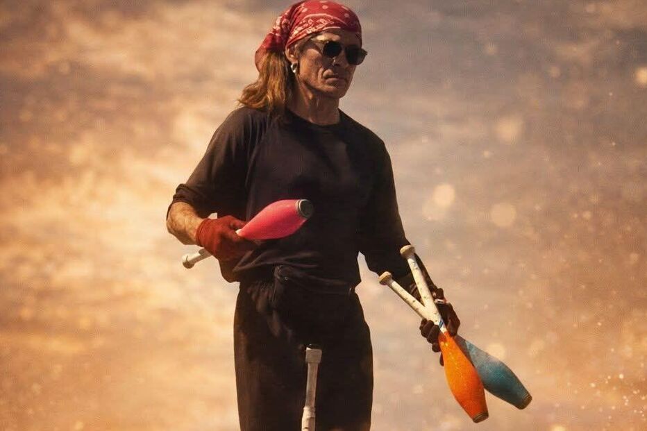 Artista de rua exibe malabarismo sobre pernas de pau num ambiente urbano