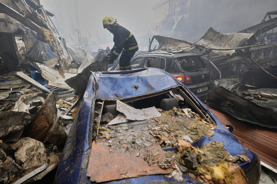 Após ataque, bombeiro inspeciona carros destruídos em Beirute