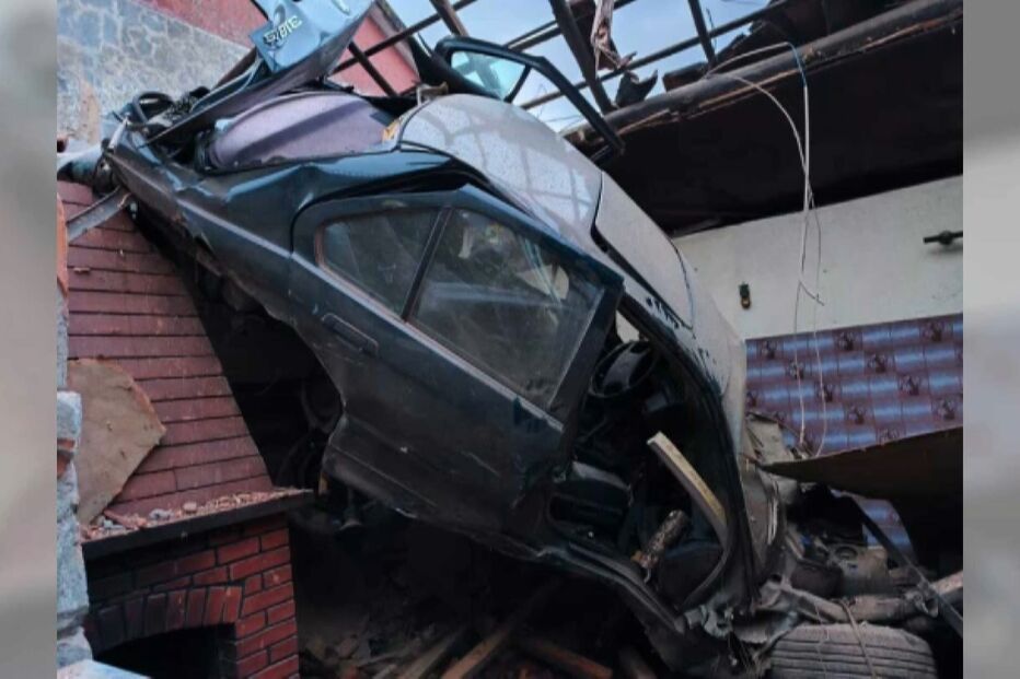 Carro danificado após acidente destrói parte de uma casa