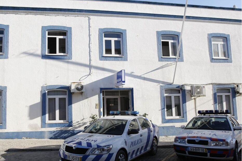 Edifício da polícia com viaturas estacionadas em frente