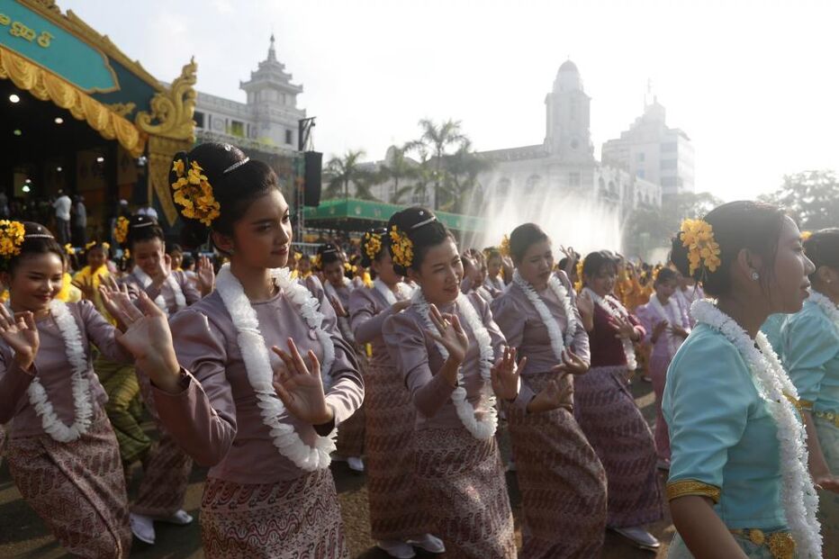 Mulheres dançam numa celebração cultural em Mianmar