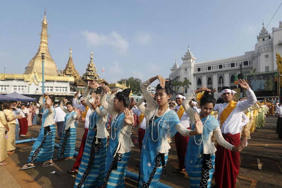 Grupo de pessoas dança em evento cultural em Myanmar