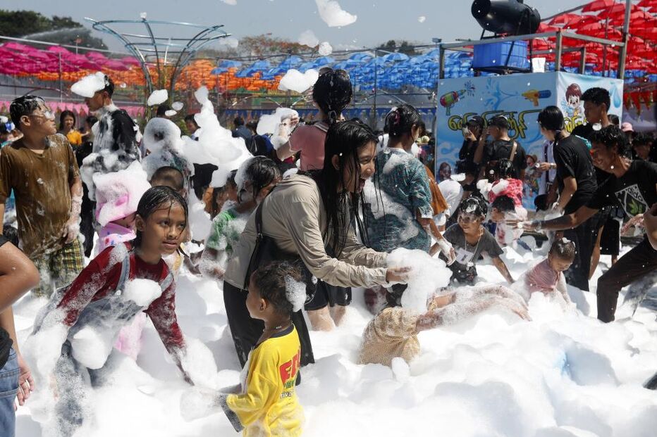 Pessoas divertem-se numa festa com espuma em ambiente aberto