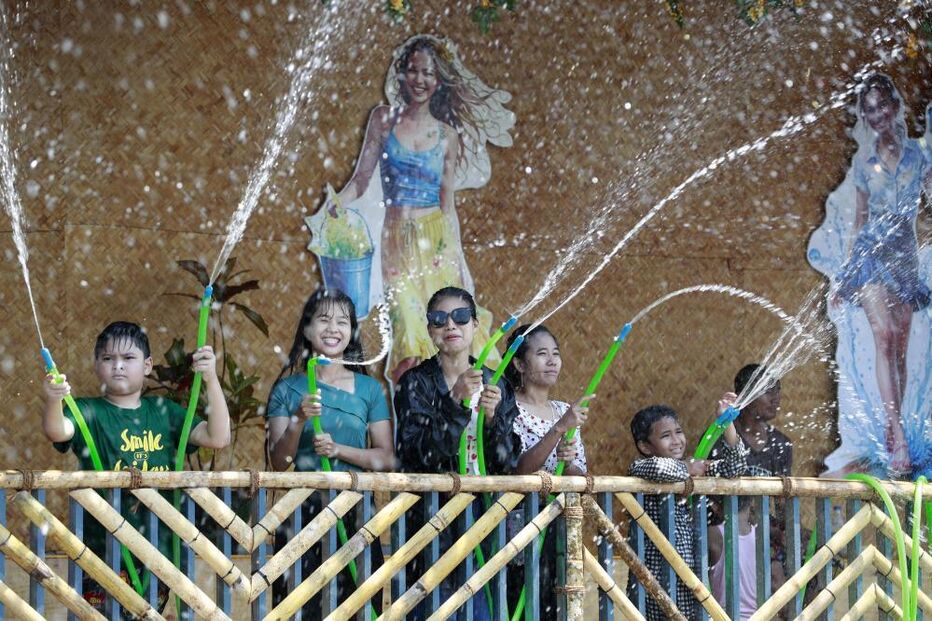 Pessoas celebram festival com pistolas de água