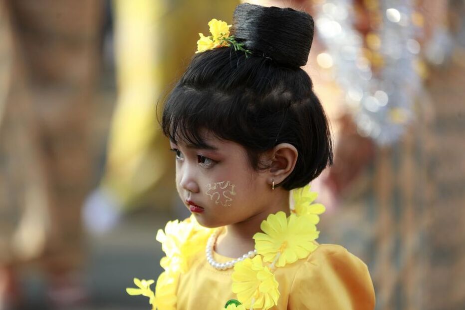 Menina vestida com traje tradicional e flores amarelas
