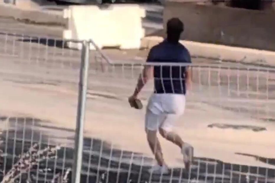 Homem salta vedação perto de cabine sanitária