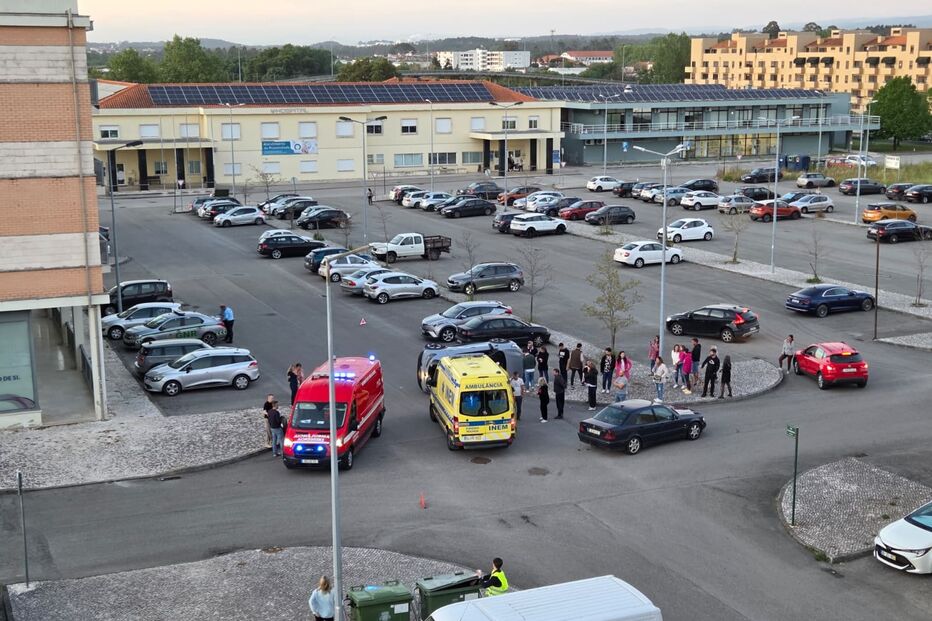 Ambulâncias e equipas de emergência num parque de estacionamento perto de edifício