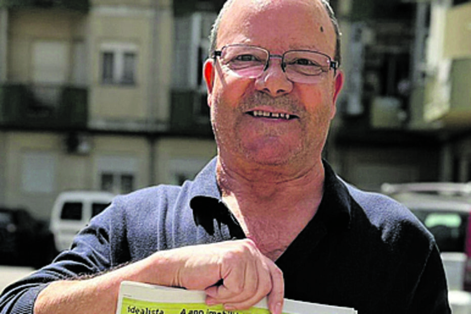 Homem exibe jornal com manchete sobre militante do PS detido por ataque à bomba