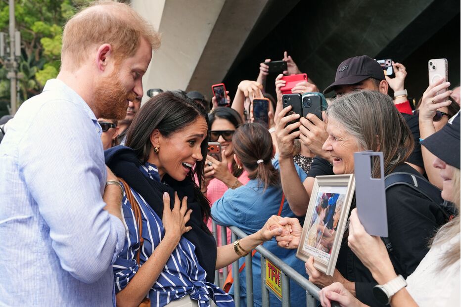 Harry e Meghan cumprimentam fãs e curiosos durante evento público