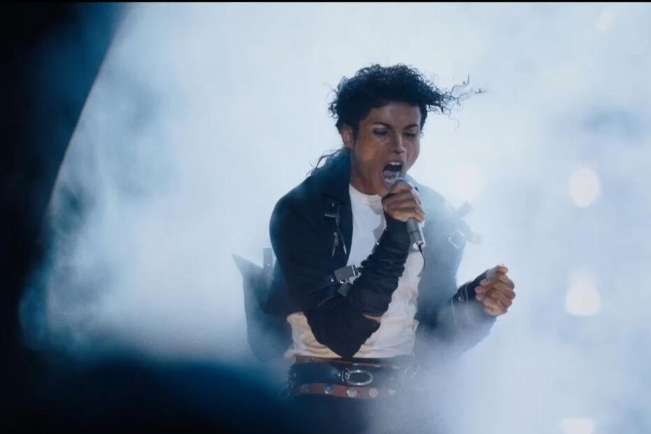 Michael Jackson canta num palco, com luzes e névoa