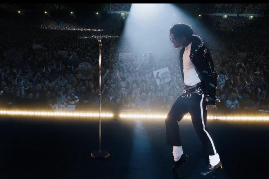 Michael Jackson atua num palco iluminado com uma multidão ao fundo