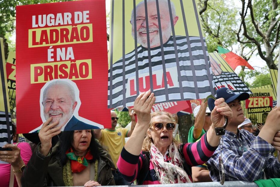 Manifestantes protestam contra Lula, com cartazes que o apelidam de ladrão e exigem a sua prisão