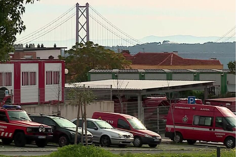 Veículos de bombeiros estacionados em Lisboa, com a Ponte 25 de Abril ao fundo