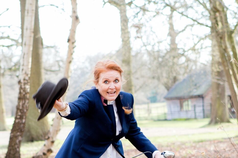 Sarah Ferguson surge sorridente numa bicicleta