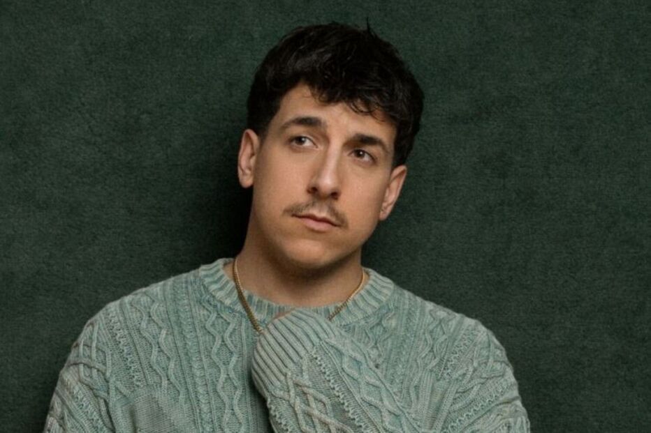 Retrato de Bustamante com um suéter verde e corrente dourada