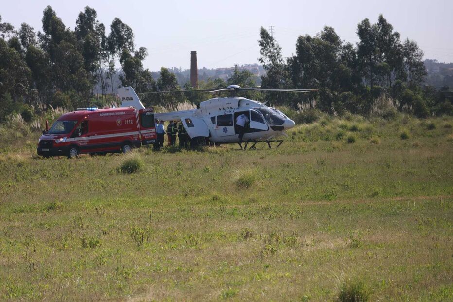 Equipa de emergência junto a helicóptero e ambulância
