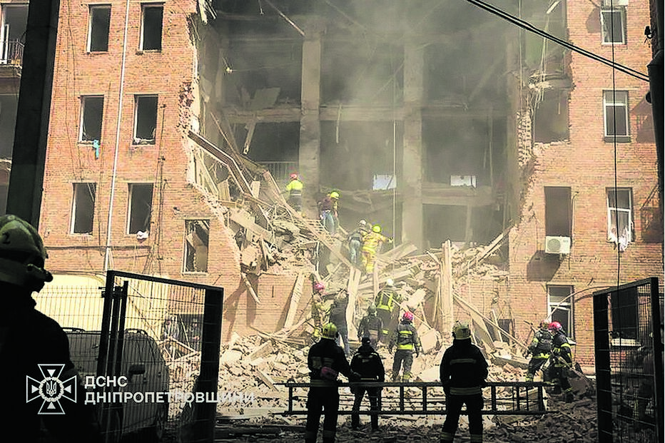 Equipas de socorro procuram vítimas após bombardeamentos russos atingirem zona residencial em Dnipro