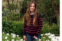 Princesa Charlotte, com 11 anos, sorri num campo florido
