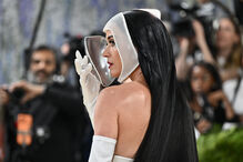 Katy Perry usa máscara facial e vestido branco num evento público