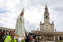 Um peregrino segura uma imagem de Nossa Senhora de Fátima durante a Procissão de Despedida, no âmbito das cerimónias religiosas da peregrinação ao Santuário de Fátima, em Oureme, Portugal, a 13 de maio de 2026