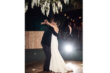 Casal dança num ambiente romântico, com flores e banda a animar a celebração
