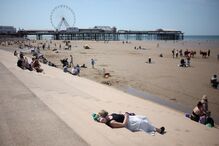 Pessoa deitada nos degraus na estância balnear de Blackpool, Grã-Bretanha