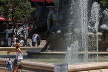 Mulher refresca-se com água de uma fonte em Skopje, República da Macedónia do Norte 