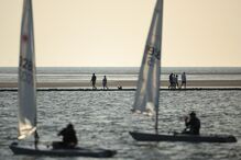 Pessoas caminham ao longo da marina em West Kirkby, Grã-Bretanha