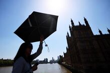 Pessoa protege-se do sol na Ponte de Westminster, em Londres, Reino Unido 