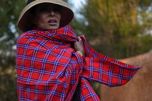 Mulher com vestes tradicionais e chapéu posa para a foto
