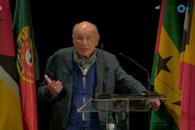 Edgar Morin discursa num evento com bandeiras de vários países