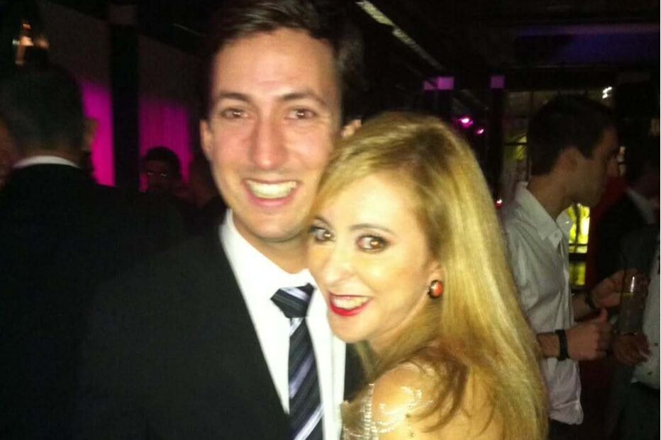 Um homem e uma mulher sorriem juntos num evento