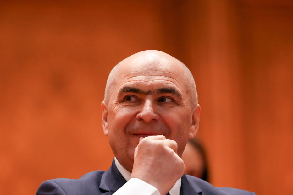O primeiro-ministro romeno, Ilie Bolojan, faz uma careta durante uma sessão parlamentar antes de uma votação de censura em Bucareste, Roménia