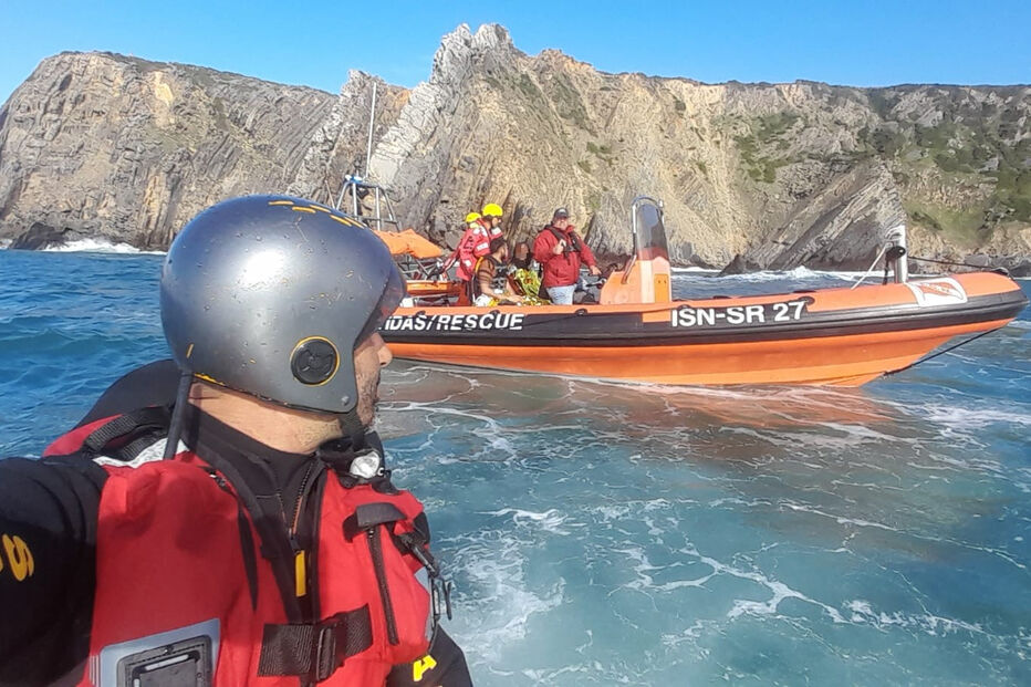 Equipa de salvamento marítimo em ação perto da costa rochosa